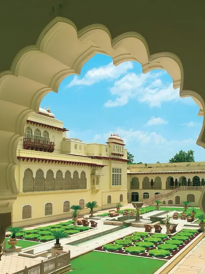 A view through a scalloped archway into the central courtyard of the Rambagh Palace Hotel. In converting this historic palace, my focus was to preserve its regal charm, ensuring that every new element honored the original architecture while providing the amenities of a five-star hotel.