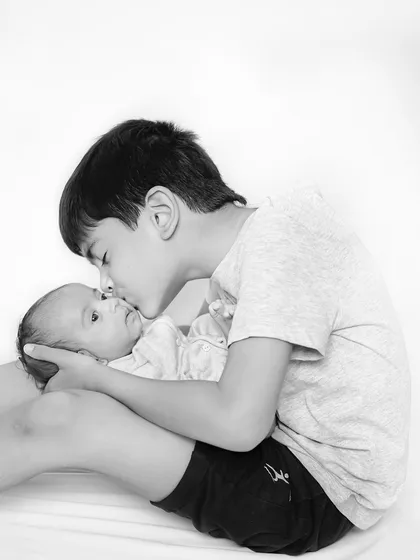 The gentlest kiss for a new baby brother. This simple, black and white portrait beautifully captures the beginning of a lifelong bond between siblings.