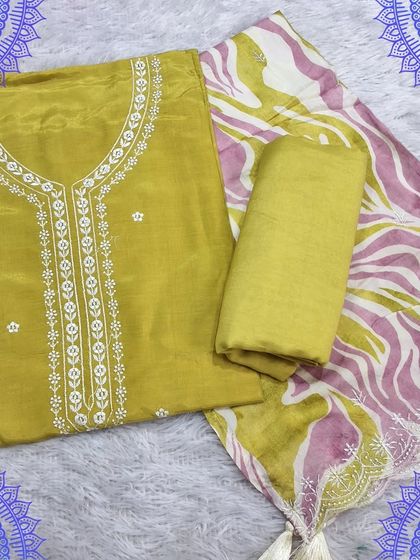 A lovely unstitched suit set in a mustard yellow. The top has simple white embroidery, and it is paired with a digitally printed dupatta with an abstract design.
