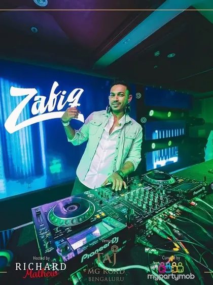 Posing by the console at the NYE 2025 party. The stage setup with the massive LED screen behind me was incredible.