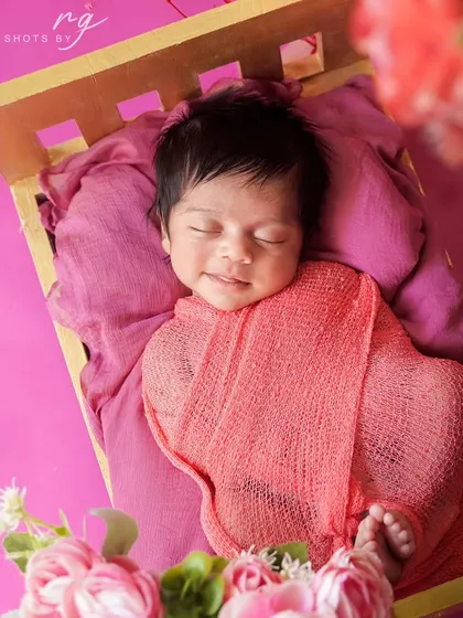 A precious, sleepy smile from a newborn girl. These are the magical, fleeting moments we aim to preserve for your family forever.