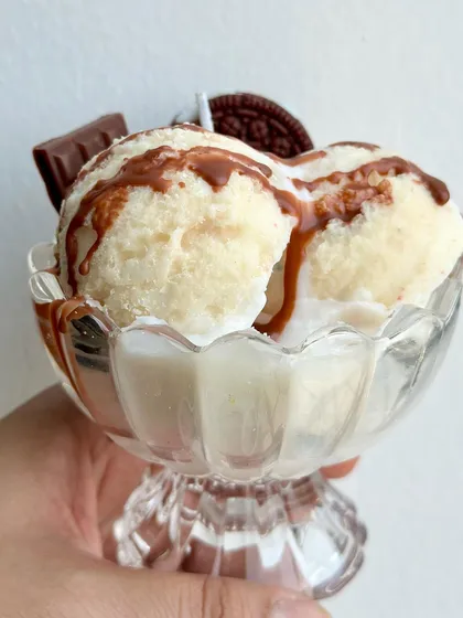 A Vanilla Ice Cream Sundae soy candle, drizzled with chocolate sauce and topped with an Oreo and chocolate bar.