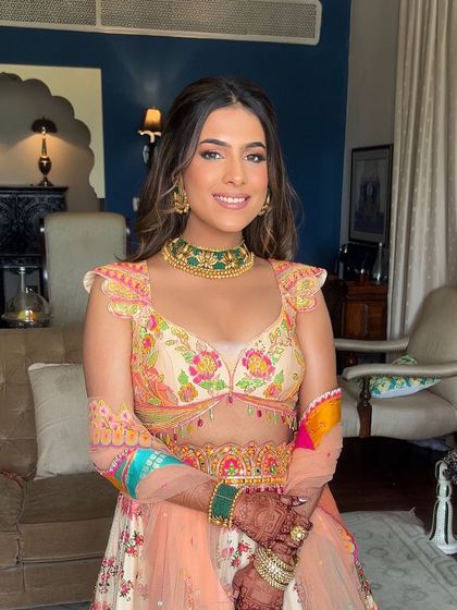 The full Mehendi look, with the bride's colorful lehenga and beautiful hairstyle creating a picture of happiness.