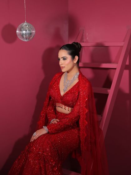 Add a touch of disco glam to your look. This shot captures the modern, edgy vibe of our red sequin lehenga, perfect for a party setting.