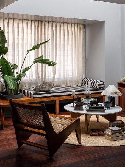 A low-profile caned armchair, inspired by mid-century design, sits in this lounge area. I often incorporate classic forms into my custom pieces, reinterpreting them with high-quality materials for today's homes.