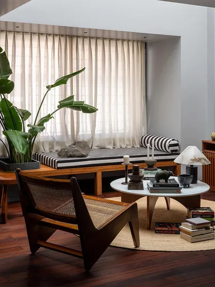 A low-profile caned armchair, inspired by mid-century design, sits in this lounge area. I often incorporate classic forms into my custom pieces, reinterpreting them with high-quality materials for today's homes.