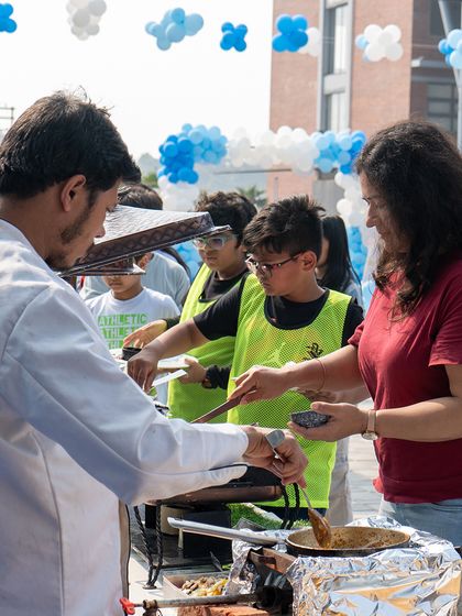Our parties include live food stations. Here, guests are being served fresh, hot pasta at an outdoor celebration.