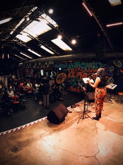 A wide shot of me performing solo at an indie music event. Even in a stripped-down setting, the goal is to fill the room with music and emotion.
