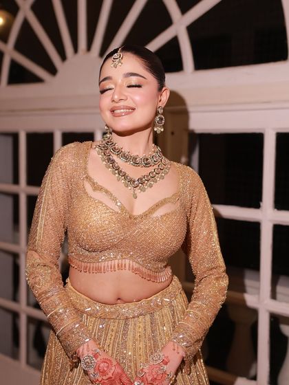 The elegance of this golden shimmer lehenga is undeniable. This happy bride-to-be looks radiant, proving that renting an outfit doesn't mean compromising on style.