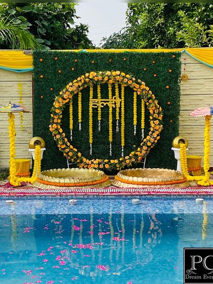 A poolside Haldi ceremony with a stunning view. The reflection of the marigold decor in the water adds an extra layer of beauty to the entire setup.