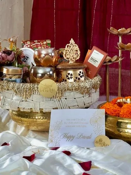 The complete Rang & Noor hamper, showcasing the beautiful assortment of items inside, including brass urlis, premium tea, and a decorative box, all set against a festive backdrop.