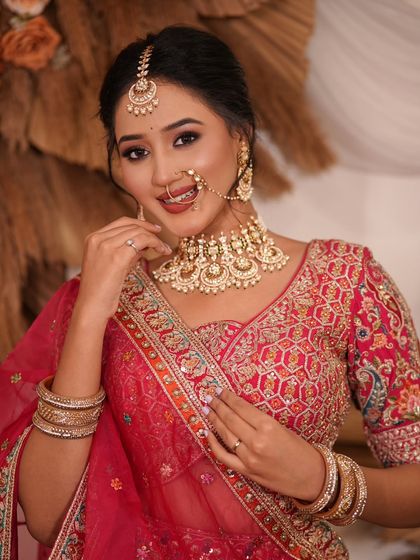 A complete bridal look featuring a heavy, gold-plated Kundan necklace, haath phool, and maang tikka, all available for rent.