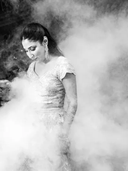 A dramatic, black and white shot of the bride entering through a cloud of smoke. This adds a touch of mystery and cinematic flair.
