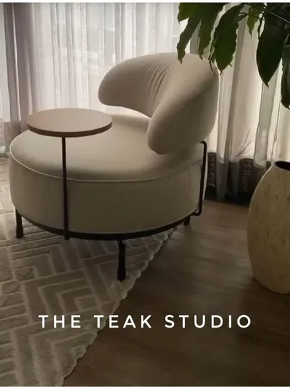 We love this design for a modern accent chair with an attached side table. It's a smart, space-saving solution that is perfect for a cozy reading nook or a compact living area.