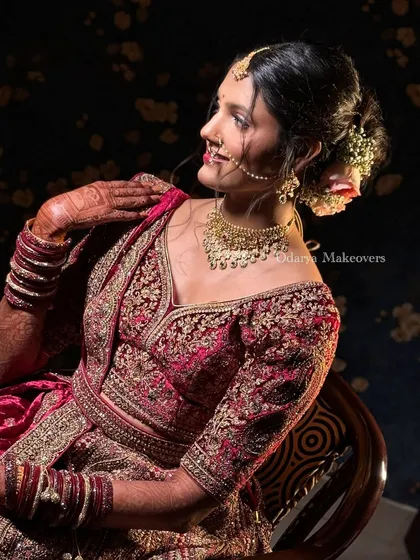 The bride's side profile, showing how the makeup, hairstyle, and jewellery come together. The intricate blouse embroidery and the floral bun create a look of pure elegance.