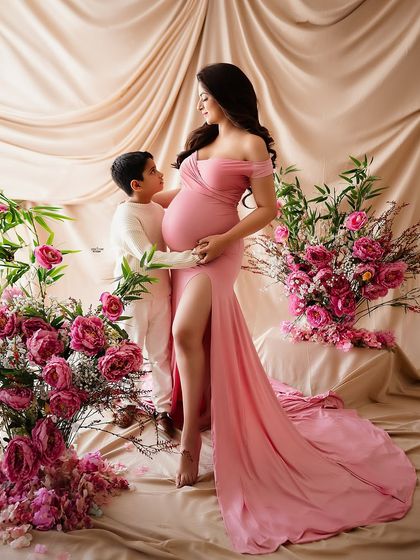 A beautiful moment between a mamma and her son, surrounded by a sea of pink flowers. He is so excited to be a big brother.