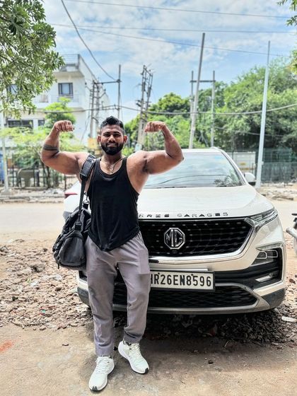 Stronger than you think. A double bicep flex in front of my car. Taking the gym gains out into the world.