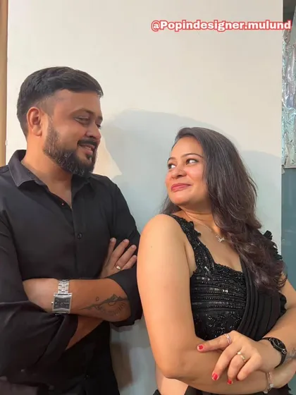 A candid, happy moment between a couple. Her smile and the elegant drape of the black saree show how confident and beautiful my outfits can make you feel.