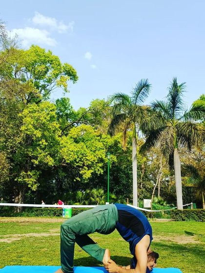 A variation of Chakrasana (Wheel Pose) in the park. Practicing on uneven ground adds an extra challenge to your balance and stability.