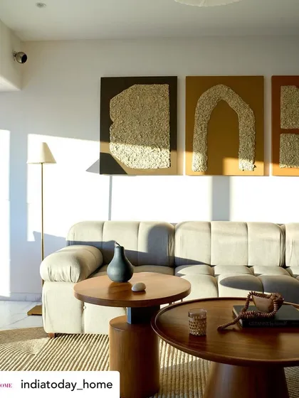 Natural light plays a key role in our designs, as shown in this photo from the 'House on the Hill' feature. The sunlight casts beautiful shadows across the textured artwork and plush sofa, bringing the room to life.