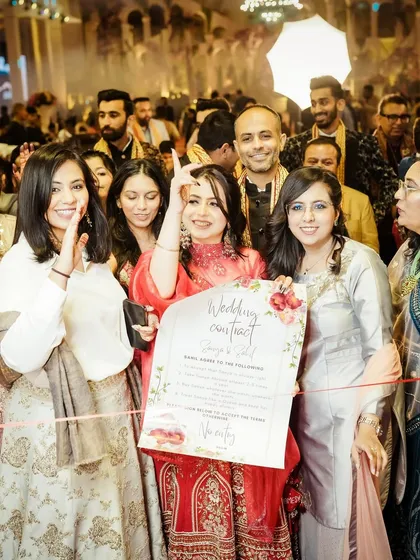 A fun wedding moment where the bride's friends present a "Wedding Contract" for the groom to sign.