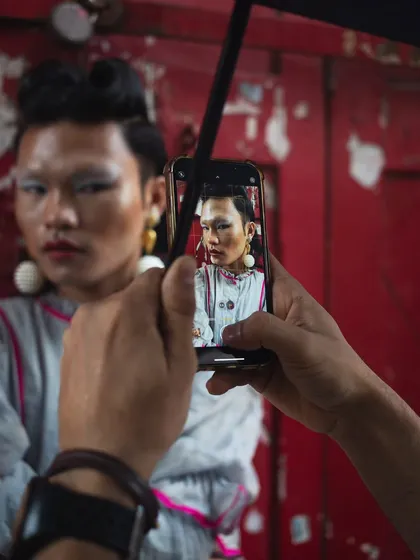 A behind the scenes glimpse of the "RIOT" shoot. This meta-image shows the shot being captured on a phone, revealing the layers of creation and documentation in a modern editorial.