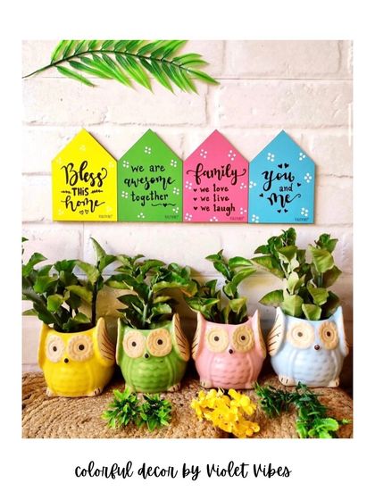 Shop colors, shop quotes, shop handmade. This image shows our colorful wooden huts with positive quotes, paired with our ceramic owl planters, perfect for creating a happy and green corner in your home.