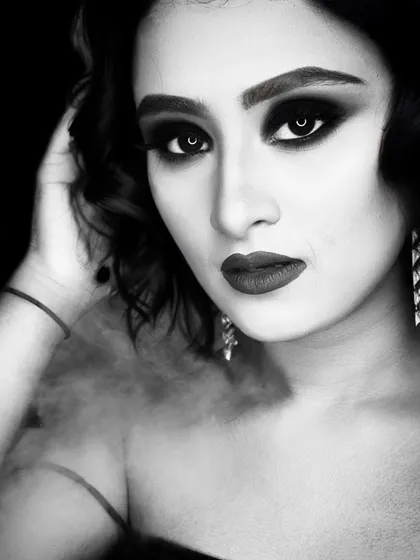 A classic portrait in black and white, highlighting the deep, smokey eyes and bold lips.