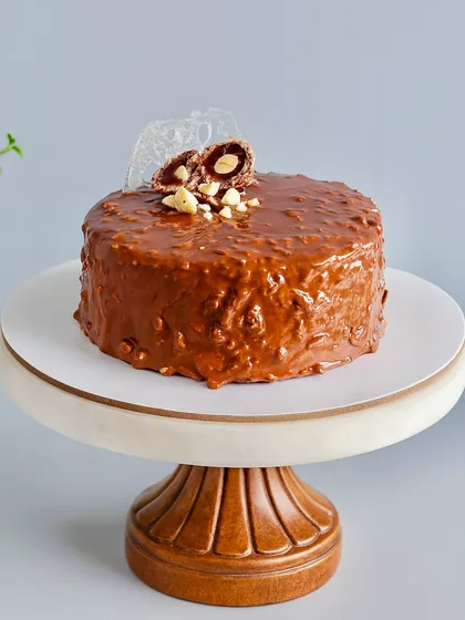 This is my signature Almond Rocher Cake, and it's a bestseller for a reason. It has layers of rich chocolate sponge and Nutella ganache, all wrapped in a crunchy almond chocolate glaze. It’s pure indulgence with a satisfying crunch in every bite.