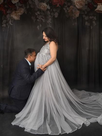 A tender kiss for the baby bump. This classic pose against a floral backdrop is a beautiful way to show the partner's love and connection to their unborn child.