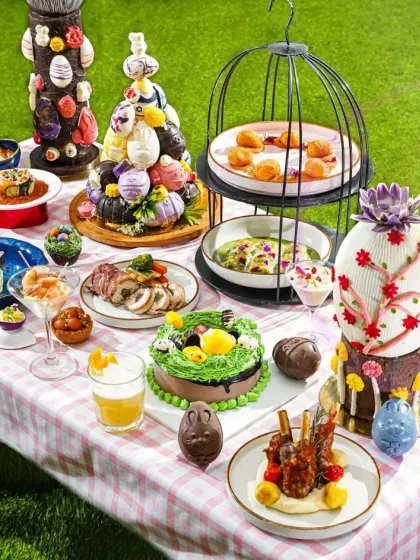 A whimsical and elaborate Easter brunch spread set on a picnic-style checkered tablecloth. This wide shot showcases my ability to handle large-scale art direction, creating a fantasy-like scene filled with themed cakes, pastries, and savory dishes.