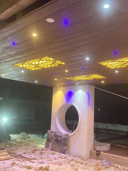 The same portico ceiling seen at night. The backlit CNC panels create a dramatic, illuminated effect, showcasing the versatility of our custom ceiling designs.