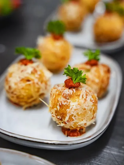 A close-up of our Mamma's Ricotta Bombs, showing the delicate garnish and savory topping. These are a must-try at our special events.