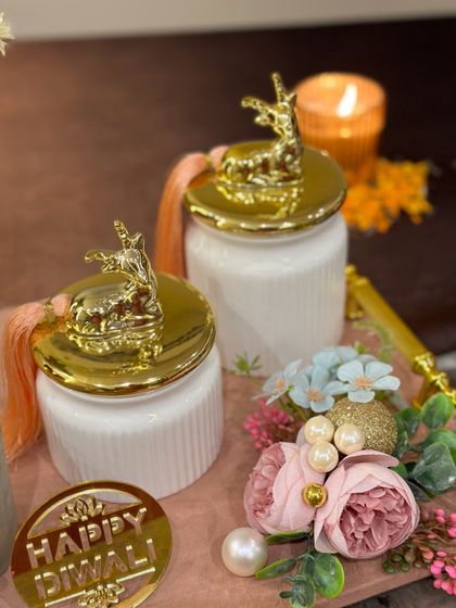 A close-up of the white ceramic jars with golden deer lids, a popular and elegant choice for our Diwali hampers.