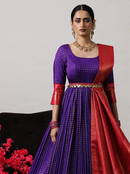 A close-up of the purple and red gown, highlighting the intricate weave of the fabric and the embellished belt.