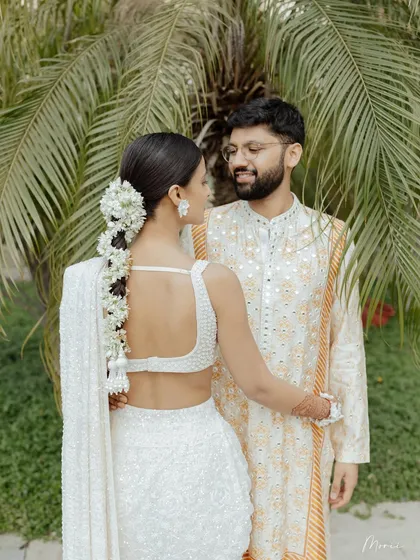 A lovely couple portrait. The groom's outfit complements the bride's white saree perfectly.