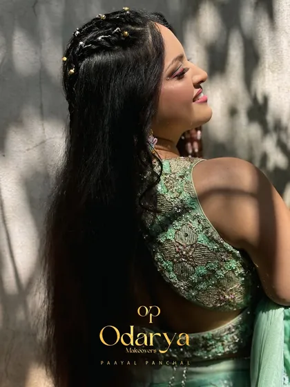 The back view of the bride's outfit and hairstyle. The open-back blouse and loose hair create a modern and chic silhouette.