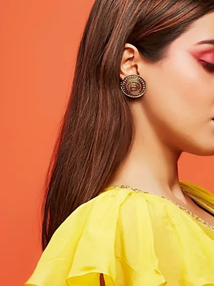 A profile shot highlighting a vibrant, artistic eye makeup look. The pop of red on the eyelid is a bold, editorial choice, perfect for a bride or bridesmaid who wants to experiment with color for a fun event like a Mehendi or Sangeet.