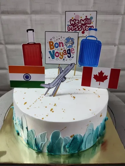 A "Bon Voyage" cake for someone moving to Canada. This travel-themed cake includes flags, suitcases, and an airplane topper.