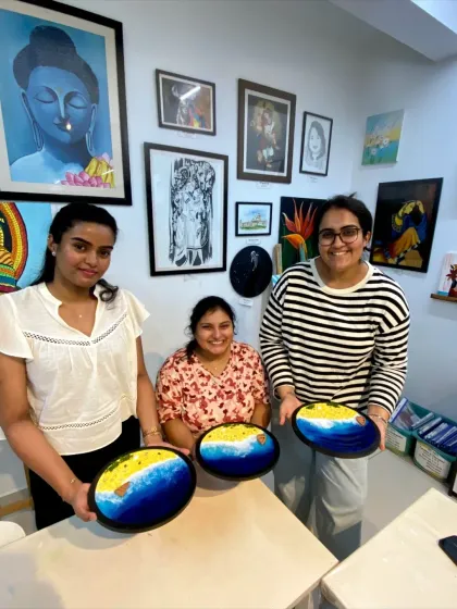 A group of friends with their finished resin beach art pieces. It's a great activity to do together and create lasting memories.