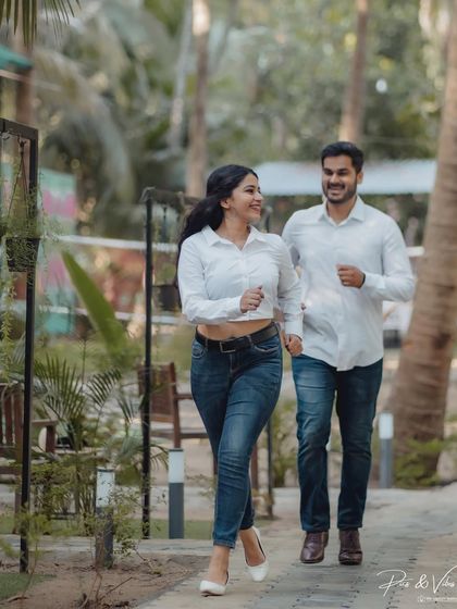 A fun, dynamic shot of the couple jogging through the resort grounds, capturing their energetic and happy vibe.