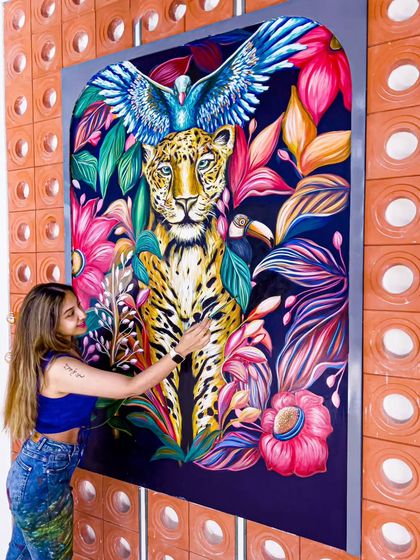 Adding details to the leopard's coat. I use acrylics to build layers of color and texture, making the animal feel alive and present in the space.