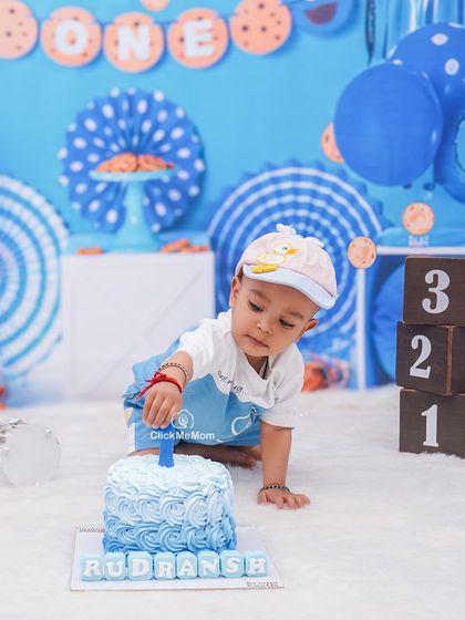 The moment of curiosity just before the smashing begins. This little one is carefully inspecting his first birthday cake, ready for the fun to start.