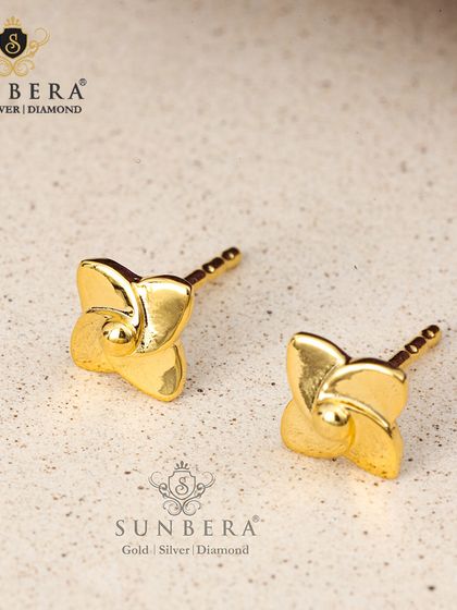 Minimalist gold stud earrings in a pinwheel or four-leaf clover design. Their polished finish and simple form make them a chic and modern accessory for any age.