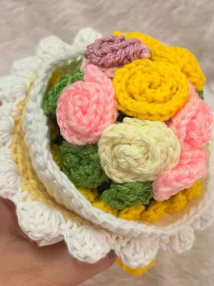A top-down look at the vibrant, multi-colored bouquet inside one of my reversible dolls. I use a mix of pink, yellow, and cream roses to create a cheerful and full floral arrangement.