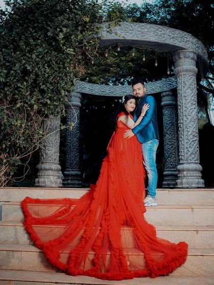 A glamorous maternity shot with a flowing red gown on the steps of our stone gazebo.