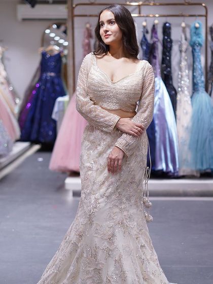 Drape yourself in the refined beauty of this cream fishtail lehenga, where minimalism meets timeless elegance.