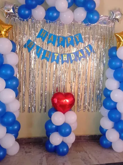 A simple birthday decoration with two balloon pillars and a shimmer curtain backdrop. This is a great option for smaller spaces or budgets.