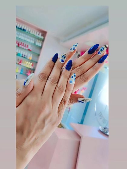 A bold and beautiful evil eye design on long stiletto nails. The vibrant blue and white pattern is striking and on-trend.
