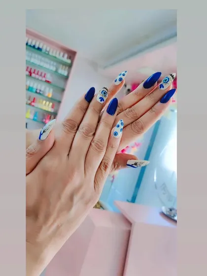 A bold and beautiful evil eye design on long stiletto nails. The vibrant blue and white pattern is striking and on-trend.